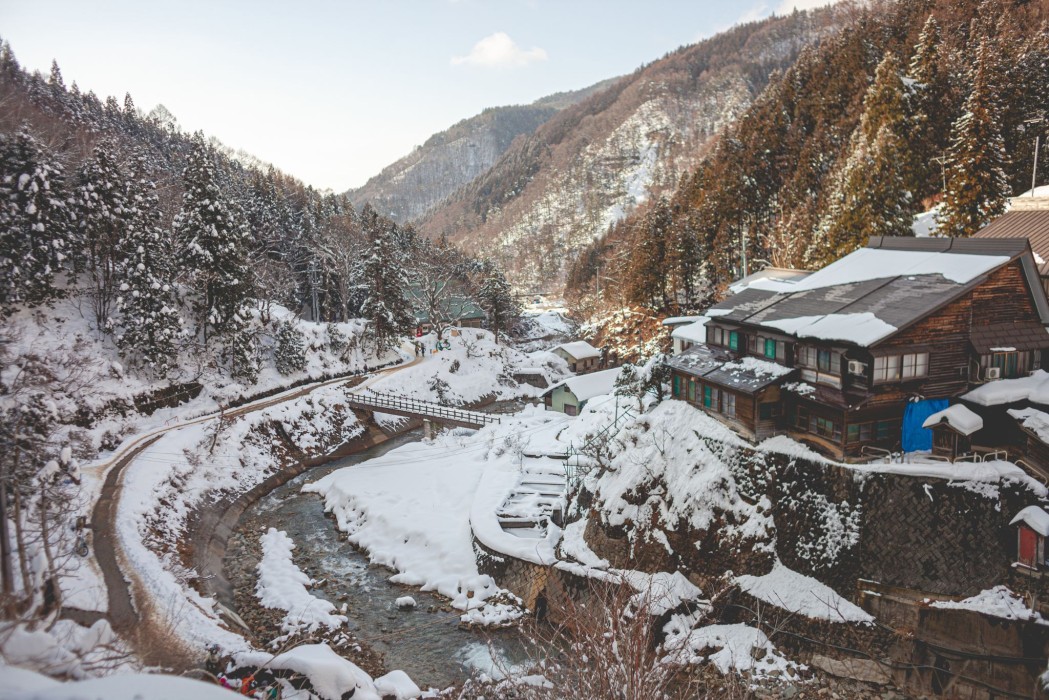 A stunning view of a serene winter landscape in India, featuring snow-capped mountains and lush valleys.