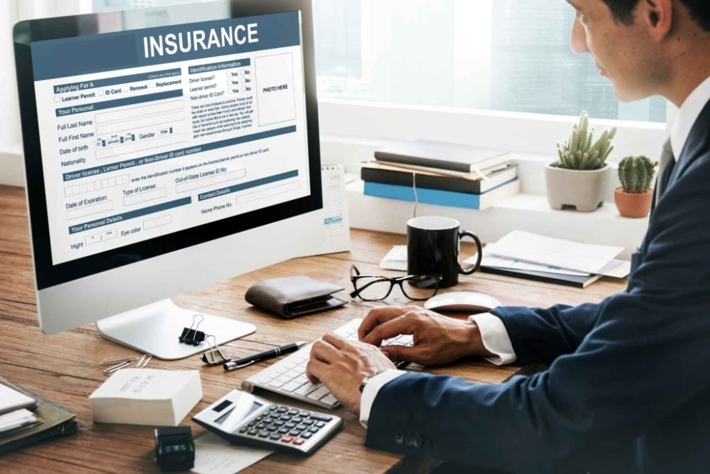 A professional reviewing an insurance form on a computer, representing the importance of insurance in relocation.