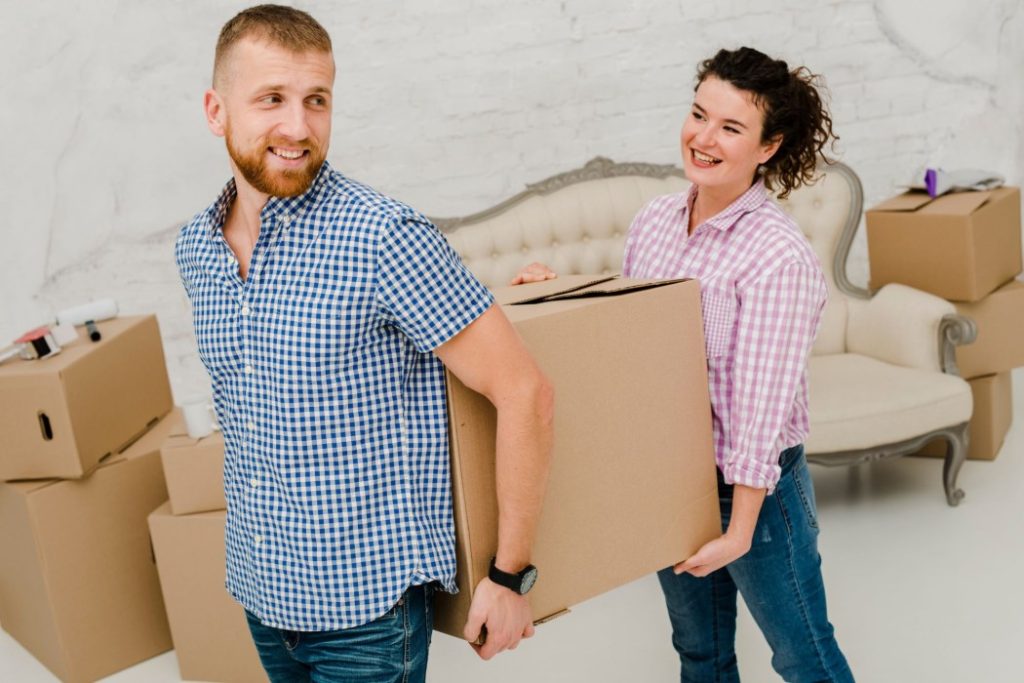 Moving truck being loaded with boxes and furniture for a household move in India.